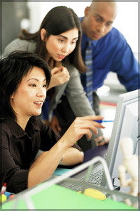 Three people looking at a computer.